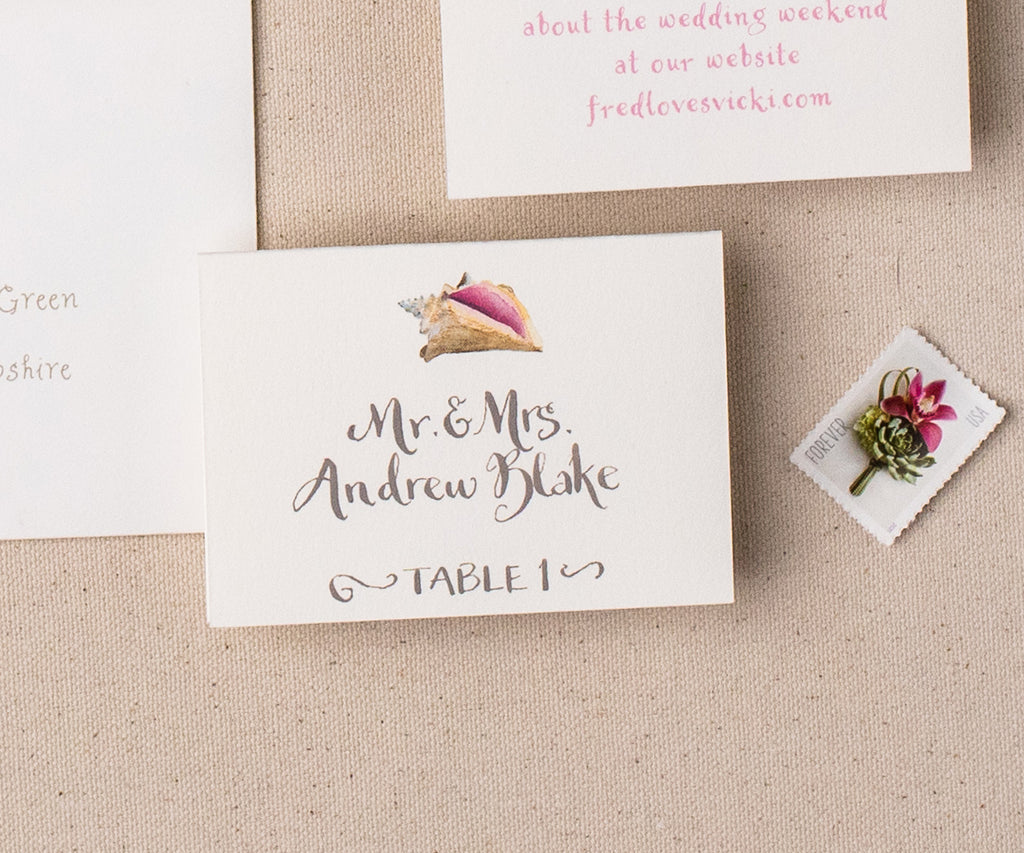 Conch shell escort card with hand calligraphy
